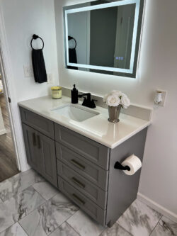 Bathroom vanity remodel with gray shaker cabinets, quartz top, and LED mirror by Sablotny Floors in Central Illinois