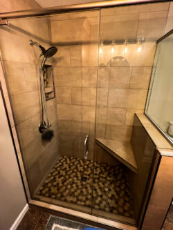 Custom walk-in shower remodel with tile walls and pebble shower floor installed by Sablotny Floors in Jacksonville IL
