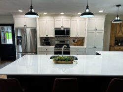 Kitchens designed and installed by Sablotny Floors featuring quartz countertops and modern lighting