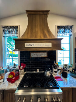 Sablotny Floors kitchen renovation featuring gas range, decorative hood, and tile backsplash in Central Illinois